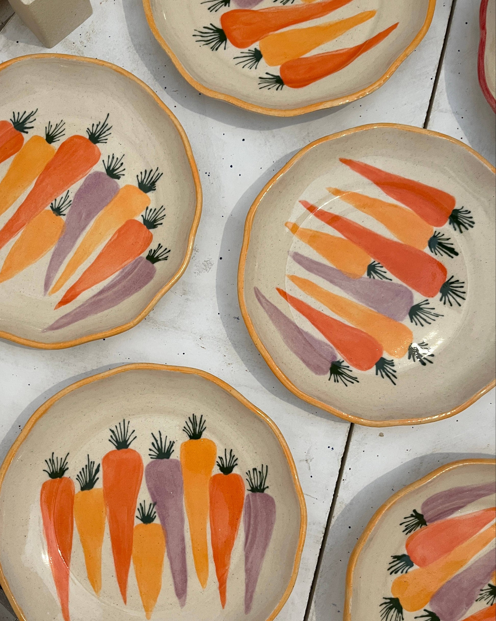 Set of ceramic plates with carrot design on a white surface