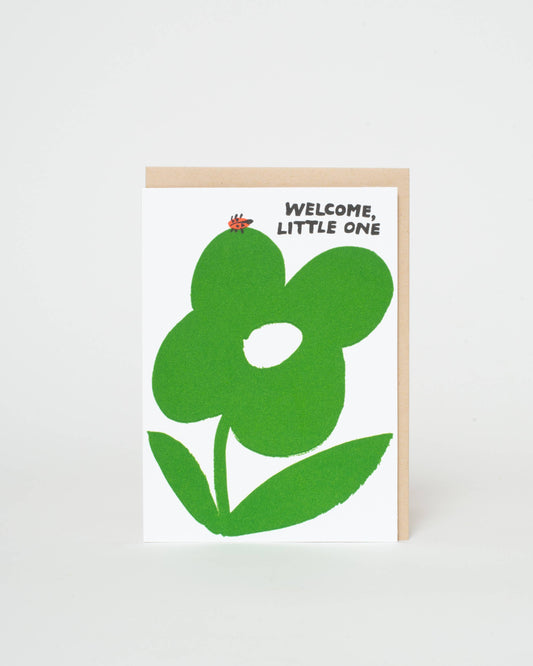 Greeting card with green flower design and 'Welcome, Little One' text on a white background