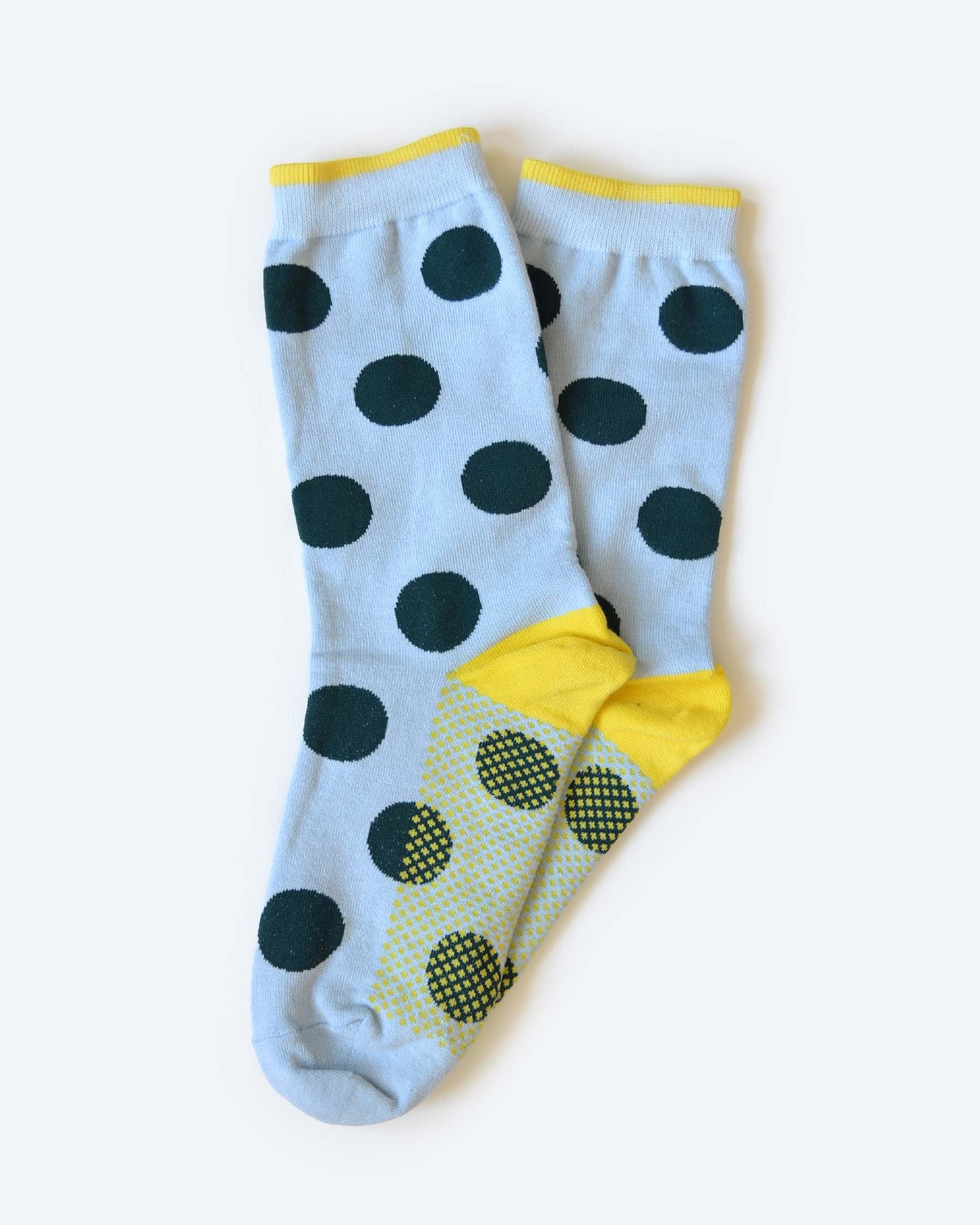 Pair of socks with black polka dots and yellow accents on a white background