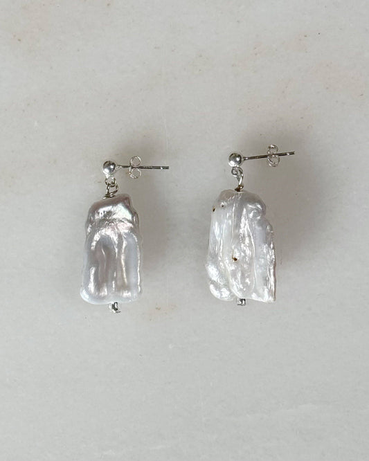 Pair of clear crystal earrings on a light gray background