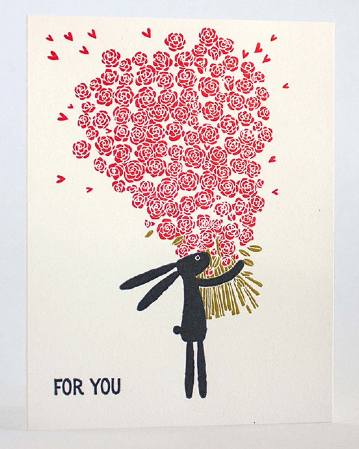 Letterpress printed card with a rabbit holding a heart-shaped bouquet of roses on a light gray background.