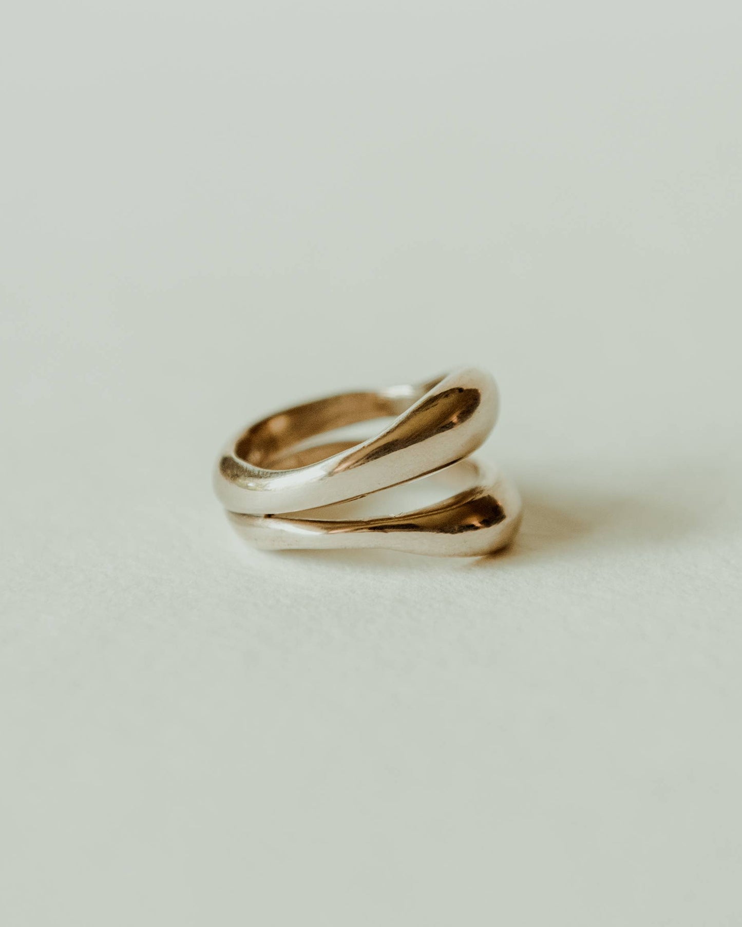 Two gold rings on a light beige background