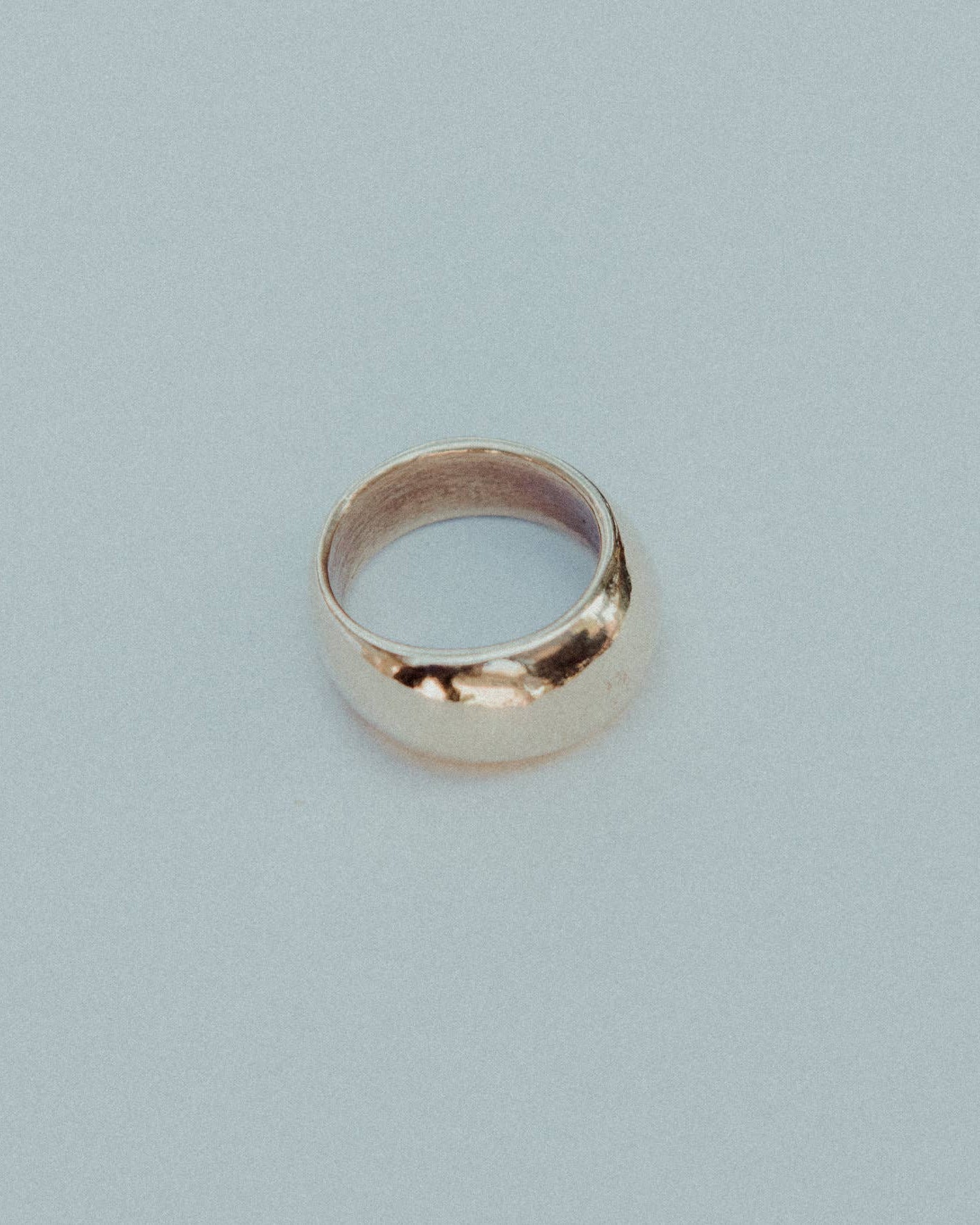 Gold ring on a light gray background