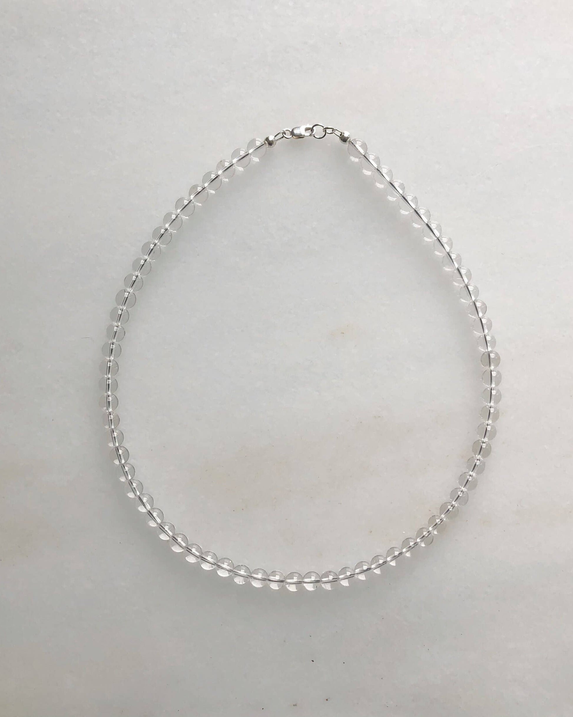 Silver necklace on a light gray background
