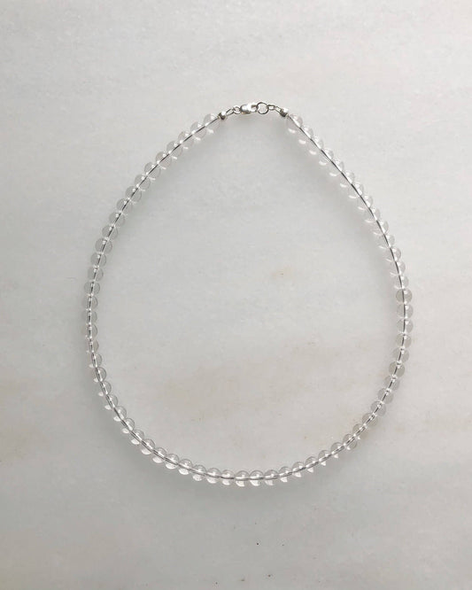 Silver necklace on a light gray background