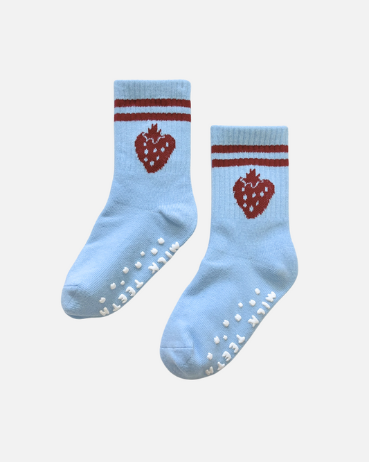 Pair of light blue socks with red strawberry design and white sole on a white background