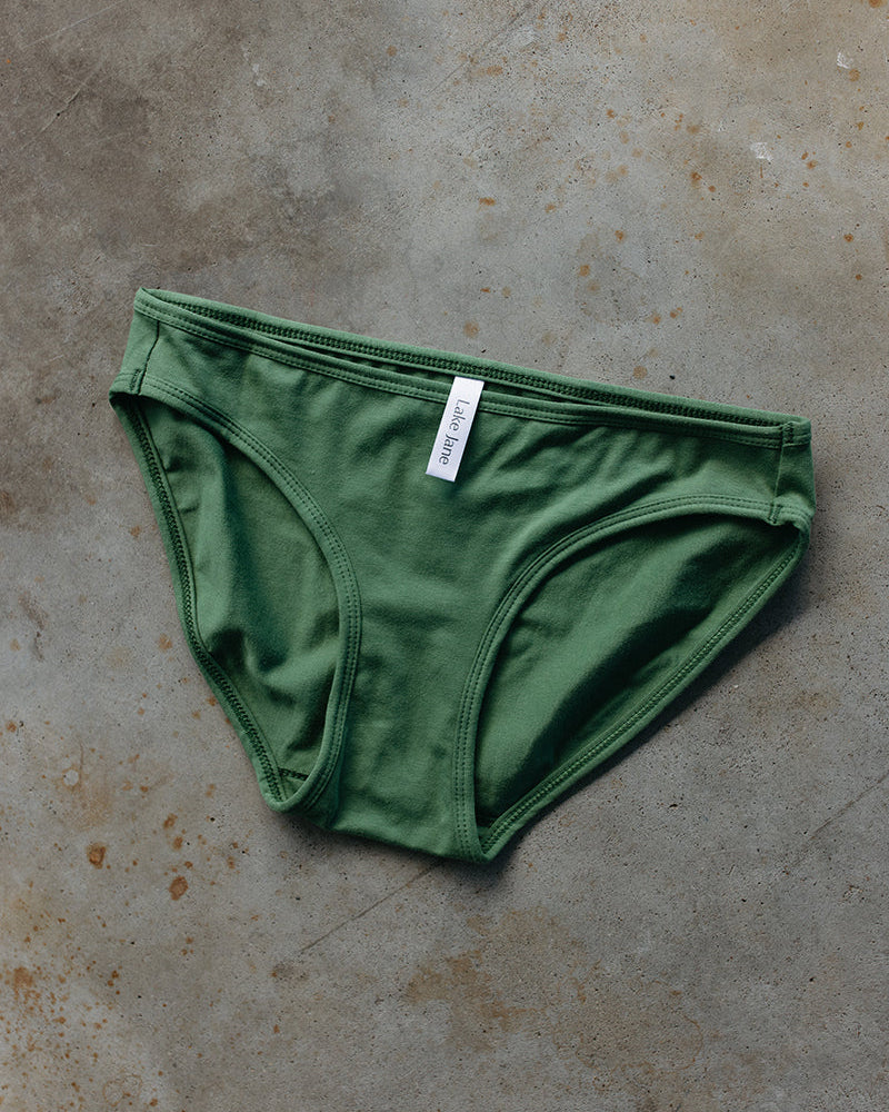 Green underwear with a label on a textured brown surface