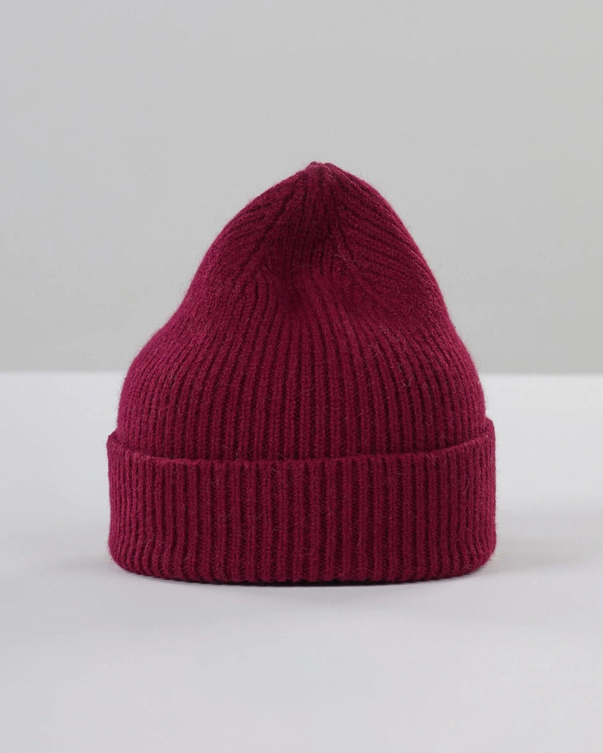Maroon knit beanie on a light gray background