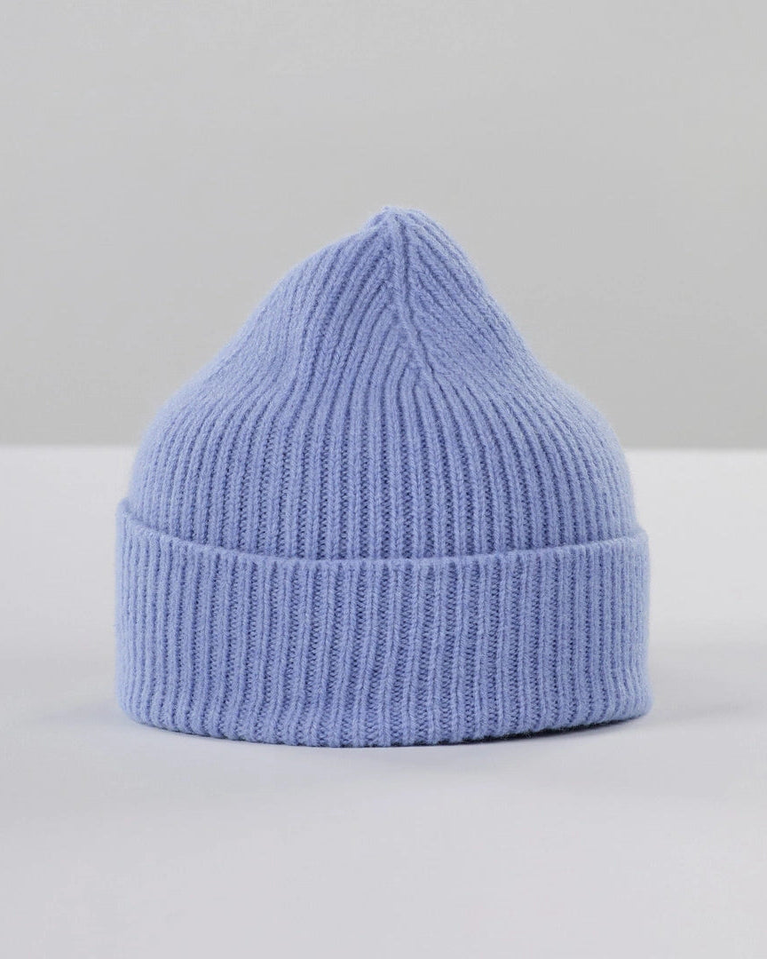 A light blue ribbed knit beanie hat, photographed on a clean white surface with a light gray background.