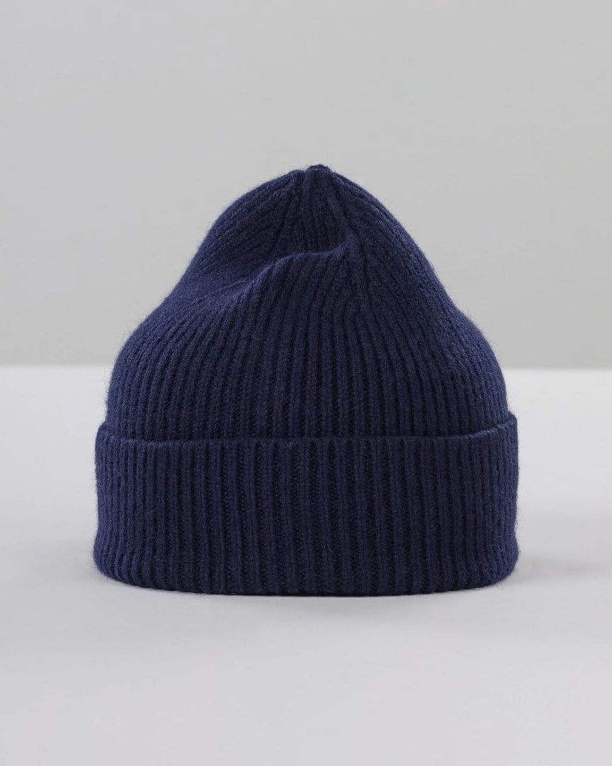 Navy blue knit beanie on a light gray background
