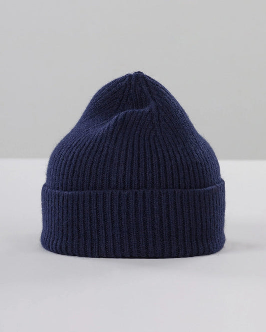 Navy blue knit beanie on a light gray background