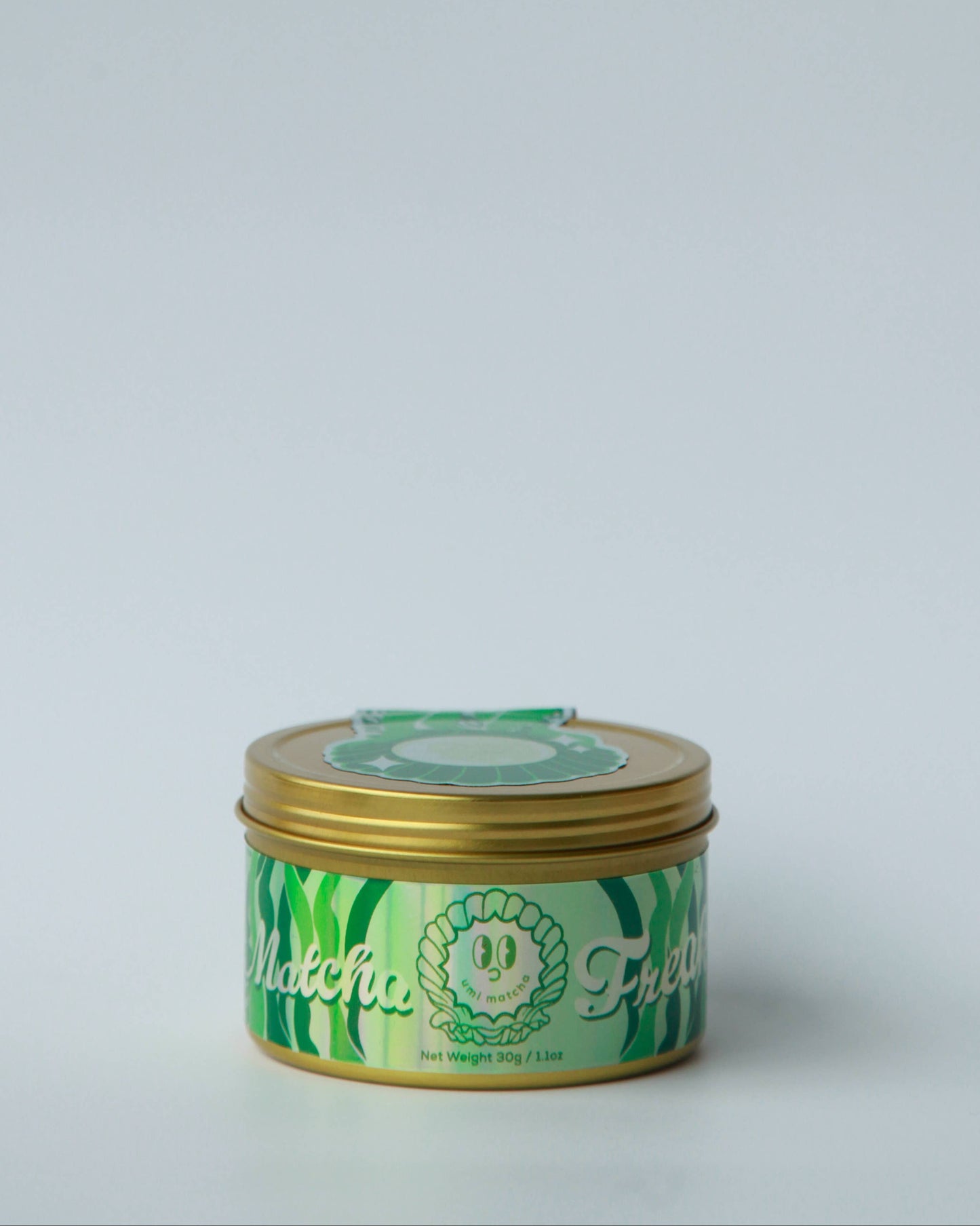 Matcha green tea tin with gold lid on a white background
