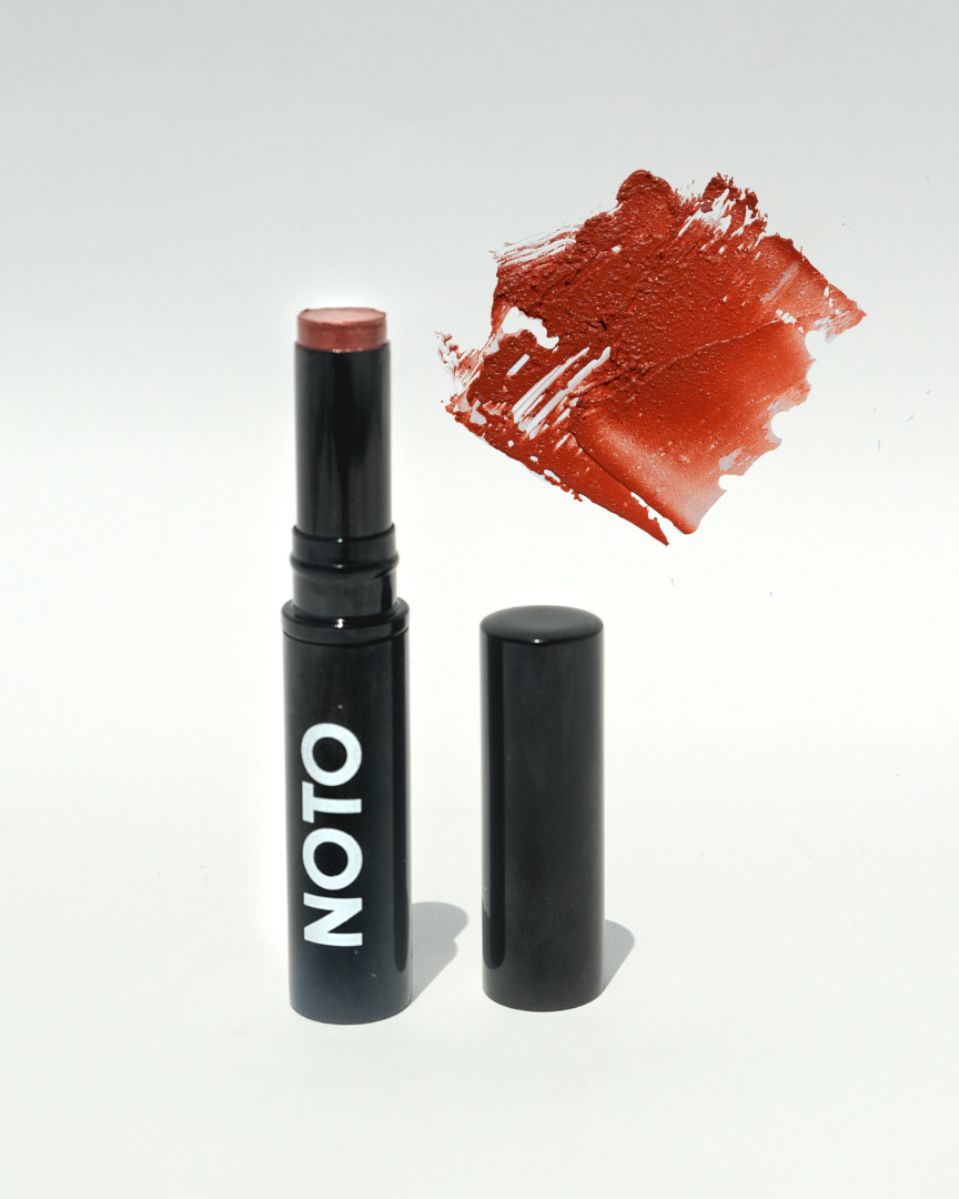 Lipstick with 'NOTO' branding and a swatch of red color on a white background