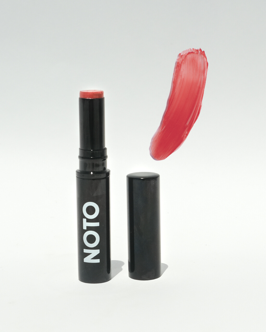 Lipstick with 'NOTO' branding and a swatch of red color on a white background