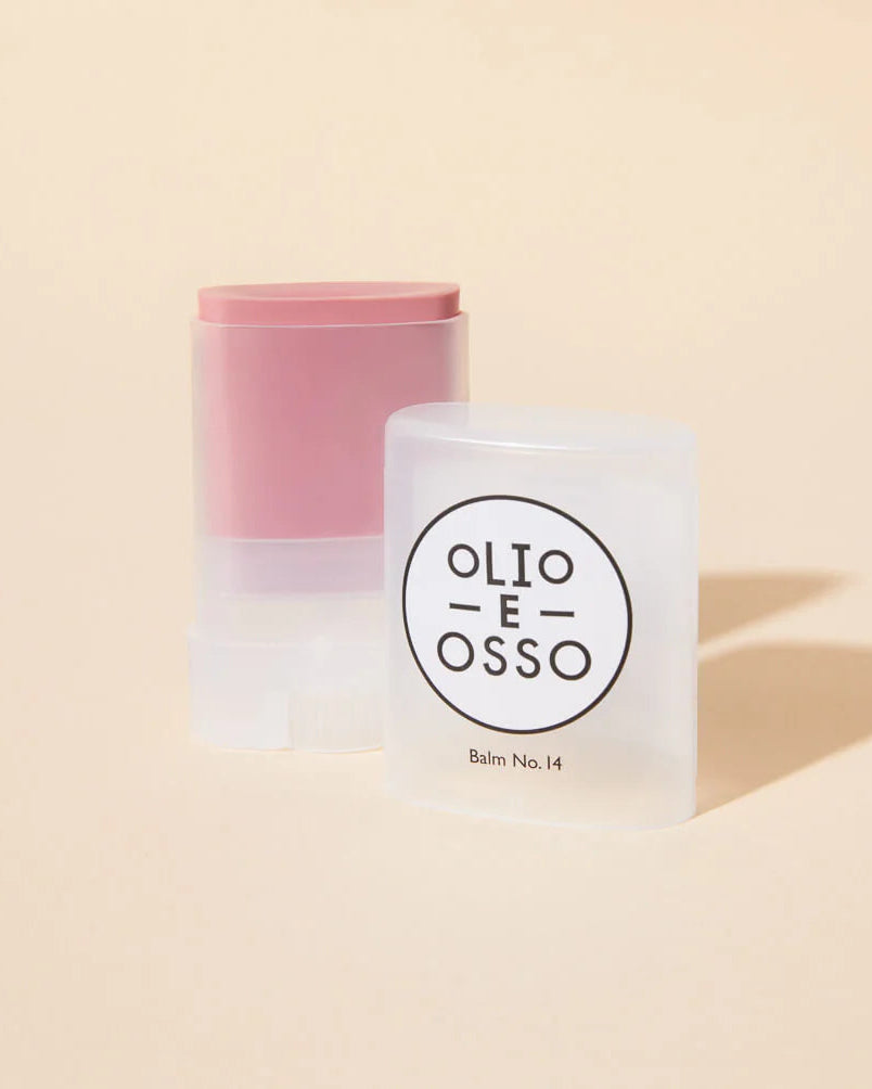 Lip balm with pink cap and white container on a beige background, featuring 'Olio E Osso' branding.