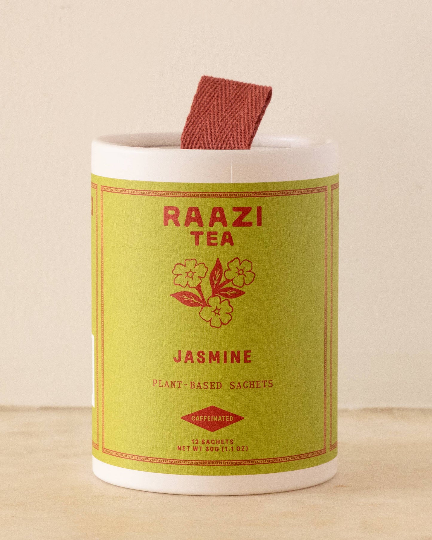 Raazi Tea Jasmine tea canister on a wooden surface with a beige background