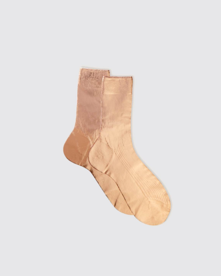 Pair of beige socks on a light gray background