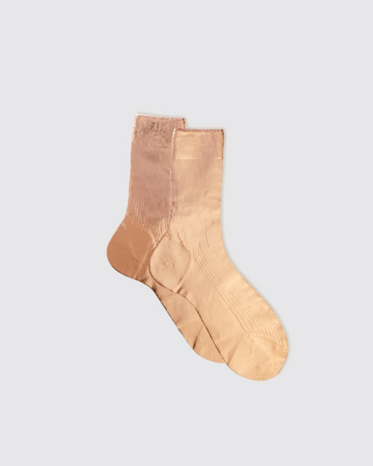 Pair of beige socks on a light gray background