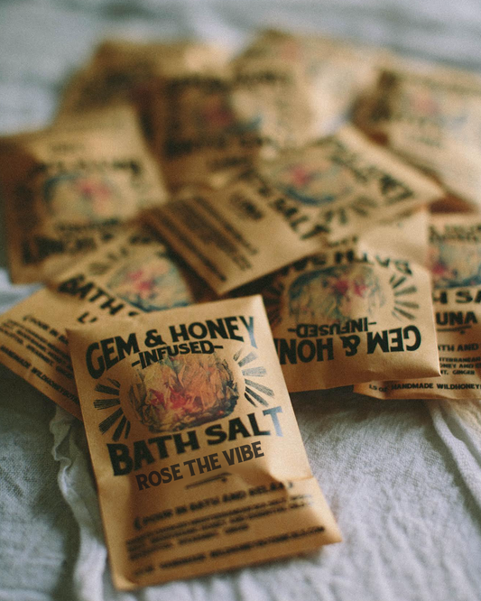 Bath salt packets with 'Gem & Honey' branding on a textured surface