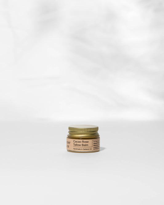 Small jar of balm with a gold lid on a white background