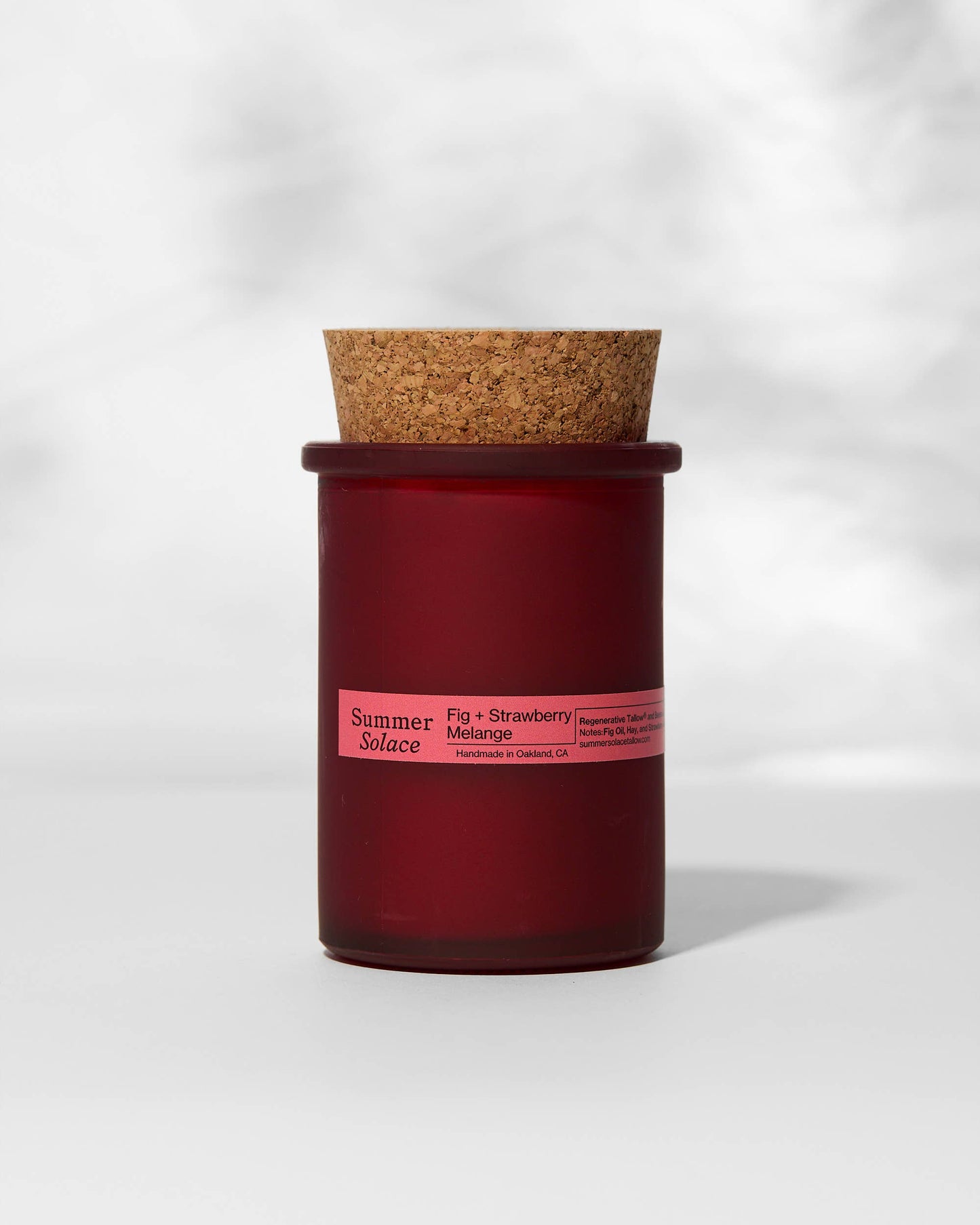 Red candle with cork lid on a white background