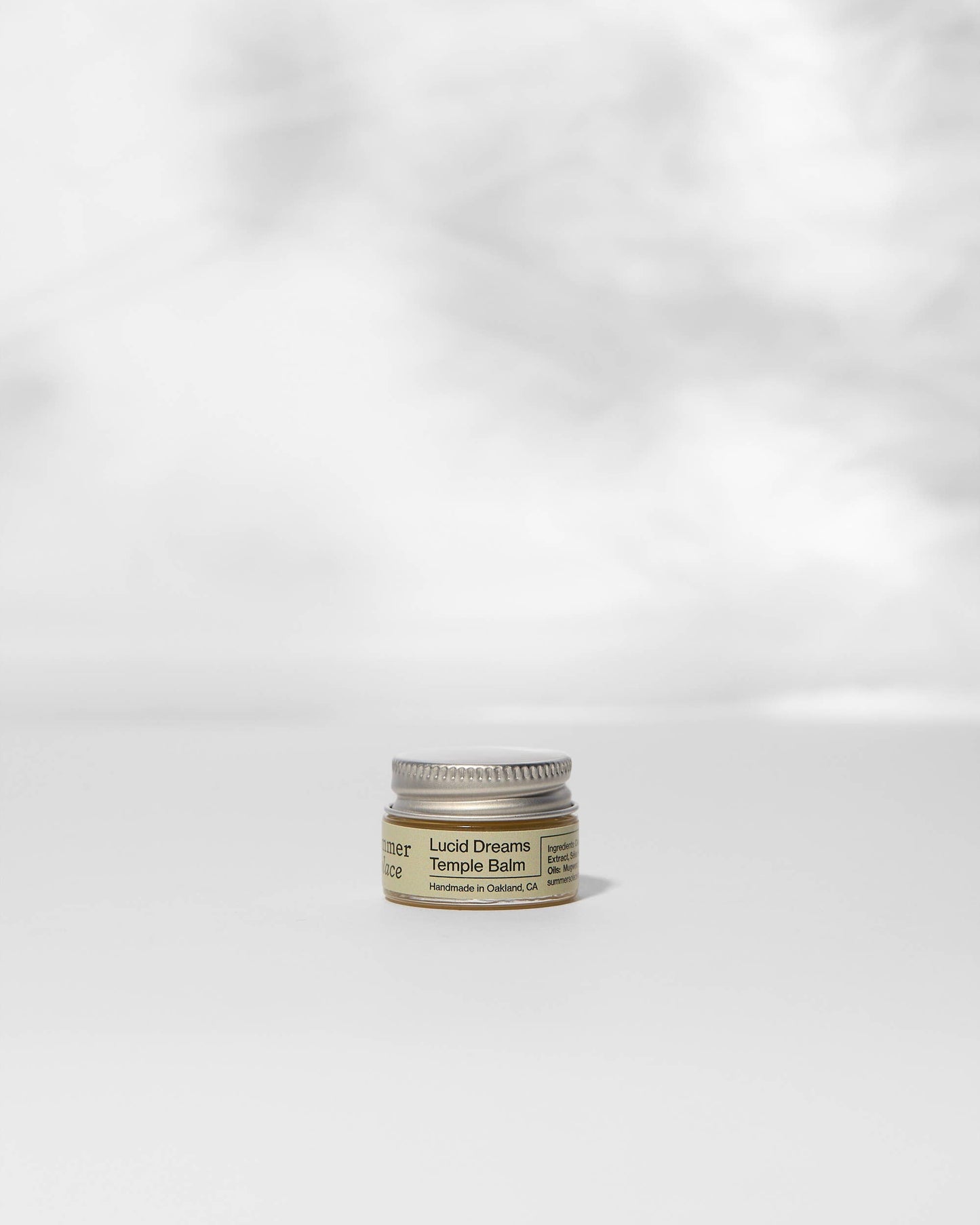 Small jar of balm on a white background
